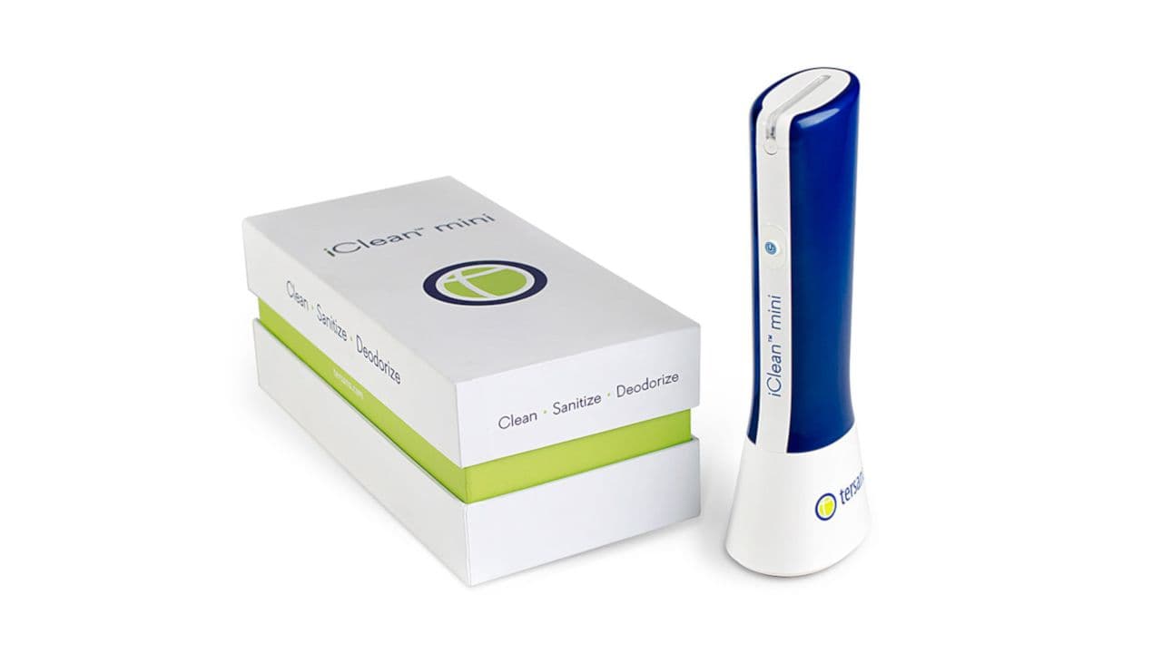 A white and green box with 'Clean Space Solution' next to a blue and white handheld Optec device.